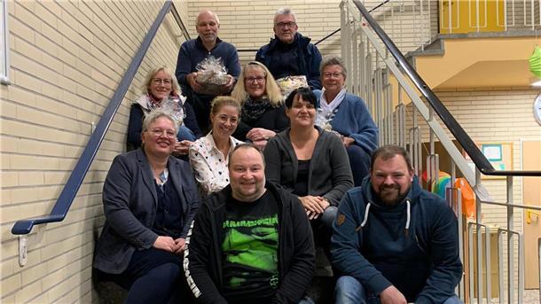 Sechs Frauen und vier Männer sitzen auf einer Treppe