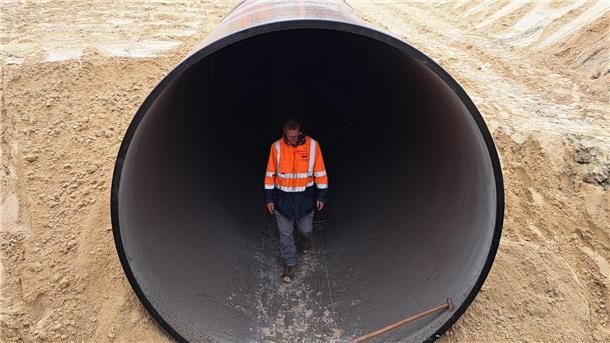 Bilderstrecke von der A27: Das sind die heimlichen Helden der Baustelle Der Polier kontrolliert das neue Rohr aus fiberglas-verstärktem Kunststoff. Es hat einen Durchmesser von drei Metern.