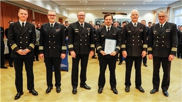 Der Preisträger, Kapitänleutnant Pascal Budzinski (3.v.r) wird umrahmt (v.l.) von Fregattenkapitän Christian Inan, Kommodore des MFG 5, Kapitän zur See Carsten Holtgreve, dem Chef des Stabes, Kapitän zur See Holger Schmitt, dem Kommodore des MFG 3, Kapitän zur See Oliver Ottmüller und Marineflieger-Kommandeur, Kapitän zur See Broder Nielsen.