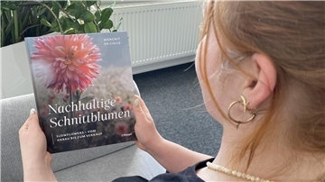 Eine Frau hält das Buch "Nachhaltige Schnittblumen" in den Händen.