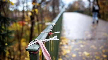 Der Rest eines Absperrbands der Polizei am  Geländer einer Fußgängerbrücke im Englischen Garten in München. Dort kam das Opfer zu Tode.