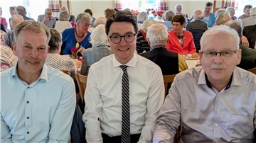 Frühlingsfrühstück wird immer beliebter: Soziale Teilhabe ist wichtig Drei Männer - Harald Sommerfeld, Christoph Frauenpreiß und Guido Dieckmann - sitzen inmitten anderer Gäste beim Frühlingsfrühstück.