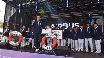 Ein Chor auf einer Bühne_ Der Shantychor „Butjenter Blinkfüer“ unter Leitung von Hergen Hasemann begeisterte mit maritimen Liedern beim Stadtfest in Nordenham. 