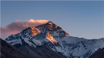 Der Sonnenuntergang färbt den Gipfel des Mount Everest.