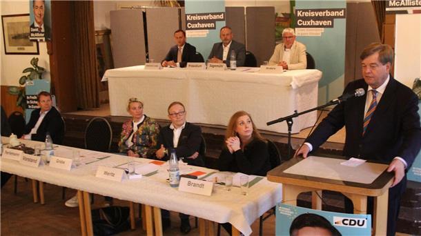 Enak Ferlemann (r.) steht am Podium und hält eine Rede. 