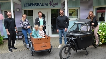 Der Traum vom eigenen Lastenrad ist wahr geworden. Das Team vom Lebensraum Kind bedankt sich für die Spende beim Fitnessstudio Mov3: Leif Forster (Mov3, von links) Helen, Lisa und Sascha, Michael Pomplun (Vorsitzender im Verein Lebensraum Kind), Mats Neumann (Geschäftsführer, Mov3) und Sarah Theinert (pädagogische Leiterin im Lebensraum Kind).