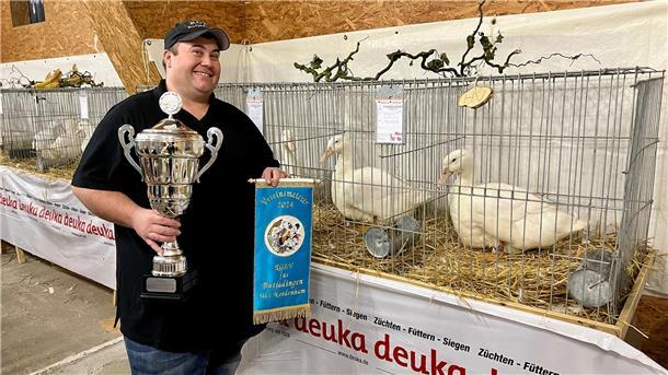 Mann neben zwei Enten bei Geflügelschau