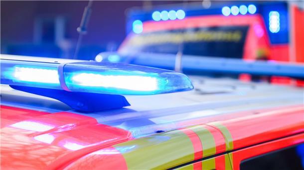 Blaulichter leuchten an einer Einsatzstelle auf einem Notarzt-Fahrzeug und einem Rettungswagen.