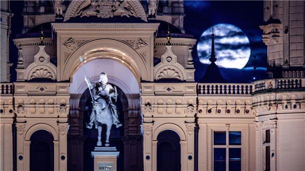 Besonders groß wirkender Mond über Deutschland Der Vollmond geht über dem Schweriner Schloss auf.