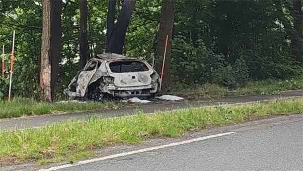 Ein Auto steht nach einer Kollision zerstört im Seitenrand einer Straße.