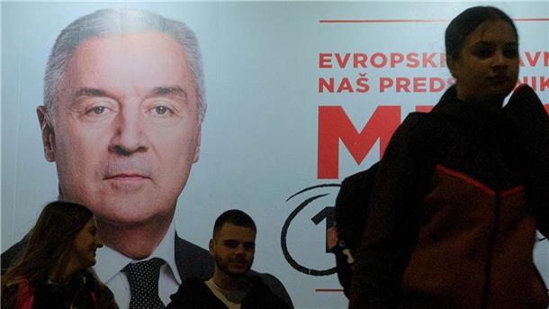 Montenegro wählt neuen Präsidenten Der Wahlkampf ist zu Ende: Menschen gehen an einem Plakat des pro-westlichen Amtsinhabers Milo Djukanovic vorbei.