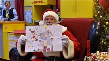 Der Weihnachtsmann zeigt in der Weihnachtspostfiliale in Himmelpforten den ausgezeichneten Wunschzettel von Jeremy aus Welzow.