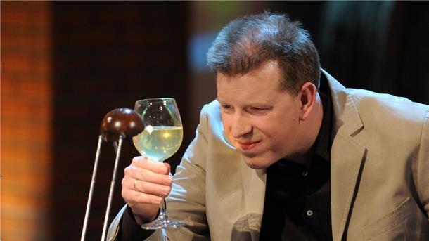 Der Wettkandidat Thorsten von Scheidt betrachtet in der ZDF-Fernsehshow "Wetten, dass..?" in Salzburg ein Glas mit Wurstwasser. Er hat gewettet, die Wurstsorte am Geschmack ihres Wurstwassers zu erkennen.