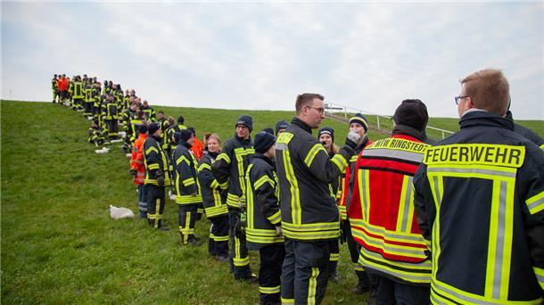 Dicht nebeneinander standen die Einsatzkräfte in Cappel-Neufeld. Ihre Aufgabe: Mehr als zehn Kilogramm schwere Sandsäcke bis zur Deichkrone durchzureichen.