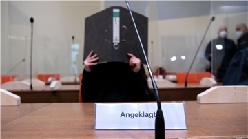 Die Angeklagte Jennifer W. sitzt vor Beginn der Verhandlung im Gerichtssaal in München. Die Frau aus Lohne in Niedersachsen soll als IS-Anhängerin im Irak tatenlos dabei zugesehen haben, wie ein kleines jesidisches Mädchen in einem Hof angekettet wurde und dort verdurstete.