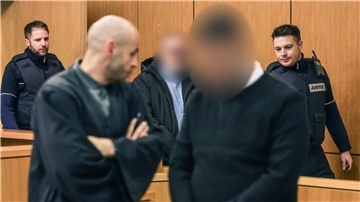 Die Angeklagten werden von Justizbeamten in den Gerichtssaal geführt.