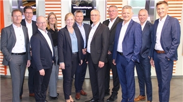 Eine Gruppen von Männern und Frauen in Anzügen, Vorstände und Aufsichtsratsvorsitzende der  der Raiffeisen-Volksbank Varel-Nordenham, der Raiffeisenbank Butjadingen-Abbehausen und der Volksbank Jever.