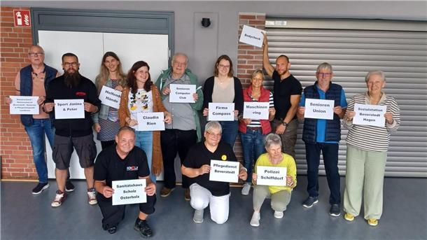 13 Personen halten weiße Schilder 