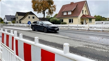 Eine Straße, die von Absperrungen umgeben ist. Auf der Straße steht ein Auto.