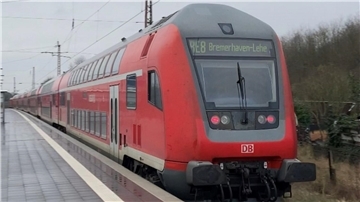 Symbolbild Bahnstrecke Bremerhaven–Bremen gesperrt: Eine Bahn hält am Bahnhof, an dem Menschen warten. 
