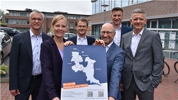 Fünf Männer und eine Frau mit einem Plakat. Es handelt sich um die Vorstände der  Raiffeisenbank Butjadingen-Abbehausen, der Raiffeisen-Volksbank Varel-Nordenham und der Volksbank Jever. 