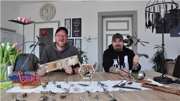 Zwei Männer mit Schmuckgegenständen, die vor ihnen auf dem Tisch liegen. Heiko Bahlmann (links) und Ralf Schmidt präsentieren neue kunsthandwerkliche Arbeiten aus dem Arbeitslosenzentrum