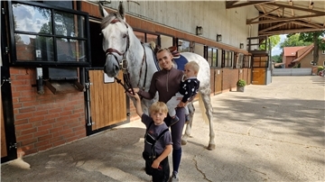 Eine Frau mit zwei Kindern und einem Pferd. 