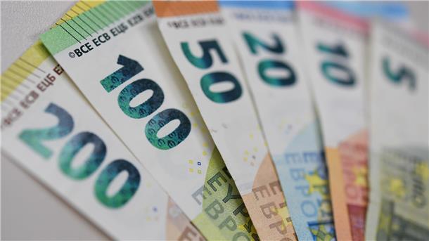 Banknoten liegen aufgefächert auf einem Tisch. 