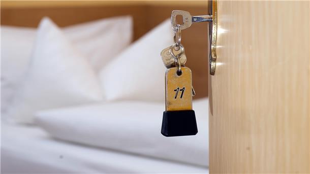 Hotelschlüssel steckt in einer Tür.