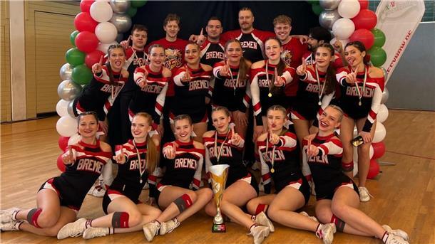 Cheerleading-WM in Japan: Bremerhavener Duo im „Team Germany“ Eine Cheerleading-Mannschaft posiert um einen Pokal.