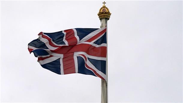 Mann kettet sich an Tor des Buckingham-Palasts Die britische Flagge weht über dem Buckingham Palace.