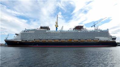 „Disney Adventure“ sorgt für volle Hotelzimmer in Bremerhaven Das Kreuzfahrtschiff „Disney Adventure“ liegt während der Bauphase im Hafen; sichtbare Gerüste, Kräne und Ausrüstung zeugen von laufenden Arbeiten am Schiff.