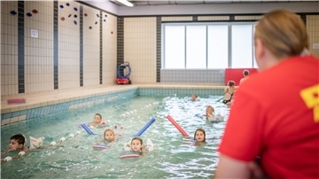 Die DLRG bietet während der Sommerferien in der Fritz-Reuter-Schule Schwimmkurse an. Im Bild: Anna Werft von der DLRG begleitet die Kinder bei den ersten Übungen im Wasser. Foto: Hartmann