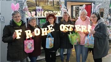 Frauen mit Osterhasenohren und einem Schriftzug „Frohe Ostern“: Der Verein macht Senioren zu Ostern
