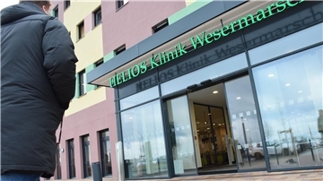 Ein Mann geht zum Eingang der Helios-Klinik Wesermarsch.