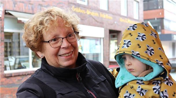 Verregneter Sonntag in Zeven: Regionalmarkt trotzt Wind und Wetter Frau mit Kind auf Arm