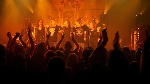 Metal-Band steht auf der Bühne, davor viele Fans.