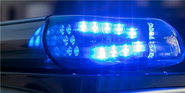 Das Blaulicht auf einem Fahrzeug der Polizei leuchtet in der Dunkelheit.