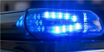 Das Blaulicht auf einem Fahrzeug der Polizei leuchtet in der Dunkelheit.