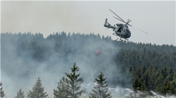 Die Feuerwehr versucht mit einem Hubschrauber einen Moorbrand im deutsch-belgischen Grenzgebiet bei Aachen zu löschen.