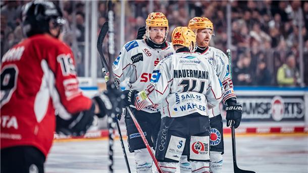 Drei Eishockeyspieler aus Bremerhaven stehen zusammen und besprechen sich. Die Pinguins sind in der Playoff-Serie gegen Köln angekommen.
