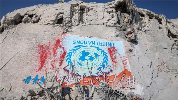 Eine Woche nach Beben: Auch Deutsche unter Vermissten Die Flagge der Vereinten Nationen ist im syrischen Sarmada verkehrt herum auf ein zerstörtes Gebäude gemalt, um auf das Ausbleiben von Hilfe durch die Organisation hinzuweisen.