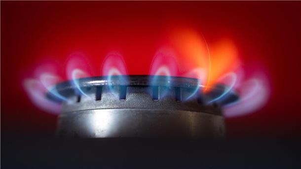 Zwei Gasumlagen sinken auf null Cent  Die Flamme eines Gasherdes brennt in einer Küche.