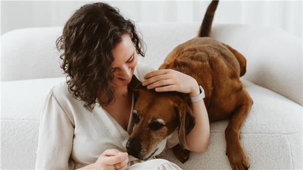 Das motiviert die Fotografin Ilona Schröder aus Nordenham Eine Dame sitzt mit ihrem Hund an einem Sofa.