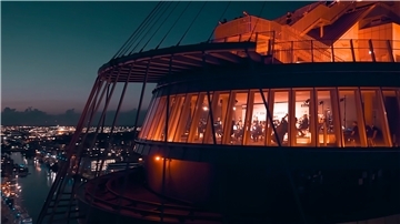 Die ganze Magie Bremerhavens: Das Atlantic Sail City Hotel, von Drohnen umkreist, wurde in der Abenddämmerung aufregend illuminiert. Oben steht DJ Cas Paris, unten in de Captain’s Lounge spielt das Orchester.