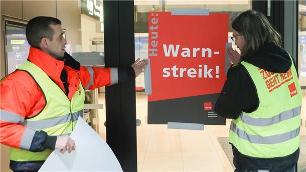 Warnstreiks an Flughäfen: Wohl keine Starts in Bremen und Hannover Airport-Mitarbeiter bringen zu Streikbeginn am Flughafen Hamburg ein Plakat mit der Aufschrift „Warnstreik“ an.
