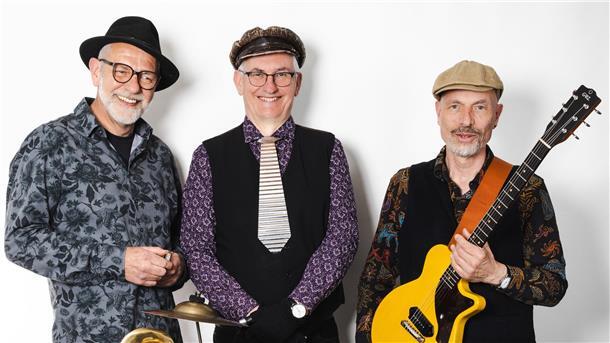 Drei Männer mit Instrumenten. Die Greyhounds Washboard Band gastiert in der Konzertmuschel in Tossens.