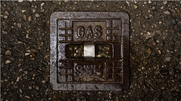 Die gusseiserne Straßenkappe einer Gasleitung.