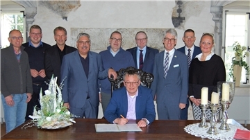 Die Hauptverwaltungsbeamten aus elf Städten, Gemeinden und Landkreisen unterzeichneten in der Burg Hagen das Strategiepapier Fairtraderegion Unterweser. Bürgermeister Andreas Wittenberg (sitzend) machte den Anfang.