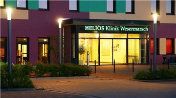 Beuleuchteter Eingang der Helios-Klinik in Nordenham in der Dämmerung.